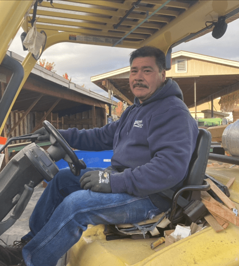 A man sitting in the driver 's seat of a construction vehicle.